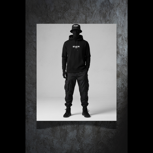 Sweat hoodie noir brodé S7VEN vue de face porté par un mannequin. Style streetwear minimaliste.